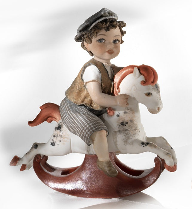 Bimbo su cavallo a dondolo - Bambola in porcellana della linea Sibania